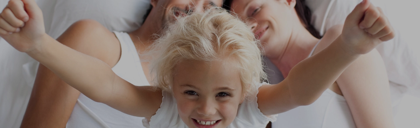 Famille heureuse sur la literie Nornuit